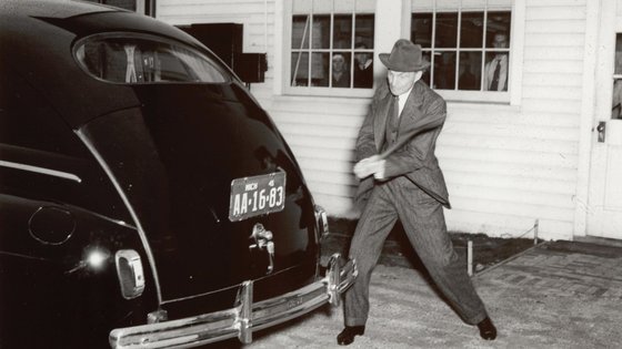 Mann schlägt auf altes Auto.