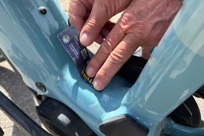 Ein blauer Registrierungsaufkleber wird auf ein Fahrrad geklebt. 