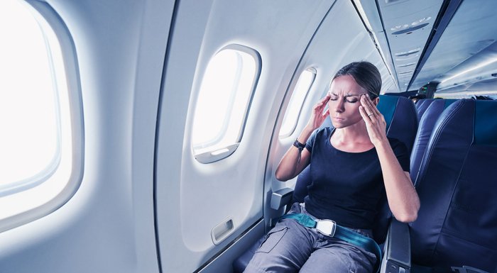 Frau mit Flugangst sitzt im Flugzeug. 