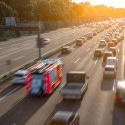 Ein Feuerwehrauto fährt durch eine Rettungsgasse auf der Autobahn. 
