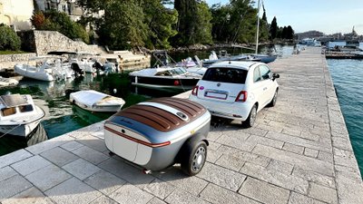 Urbanoid Booba mit Zugfahrzeug an einem kleinen Hafen.