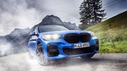 BMW X1 fährt über eine Bergstraße. 