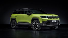 Grüner Jeep Compass vor dunklem Hintergrund.