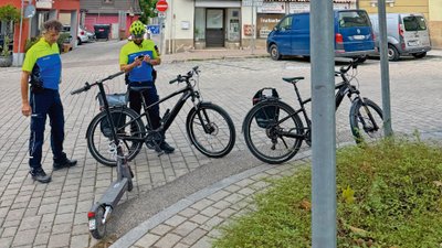 Zwei Polizisten notieren die Verstöße eines E-Scooter-Fahrers.