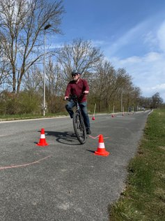 Ein Mann fährt mit dem Pedelec Slalom durch Pylonen. 