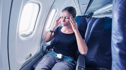 Frau mit Flugangst sitzt im Flugzeug. 
