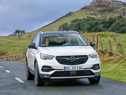 Opel Grandland fährt auf einer Straße. 