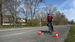 Ein Mann fährt mit dem Pedelec Slalom durch Pylonen. 
