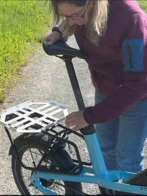 Eine Frau zieht die Sattelstütze des Cago CS 150 heraus.