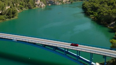 Roter Mazda MX-5 fährt über Brücke über Krka-Fluss.
