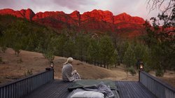 Frau sitzt beim Sonnenaufgang in Australien