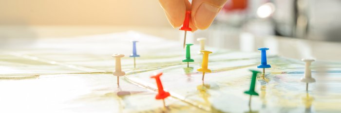 Landkarte mit verschiedenfarbigen Pins.