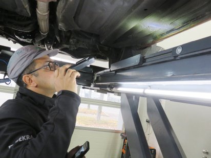 Dekra-Prüfer Markus Becker untersucht den Unterboden des Honda Prelude Coupé.