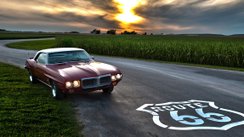 Classic Car am Rand einer Straße mit Route-66-Symbol auf dem Asphalt.