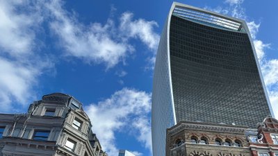 Blick auf Straßenzug in London mit historischen Gebäuden und futuristischen Hochhäusern