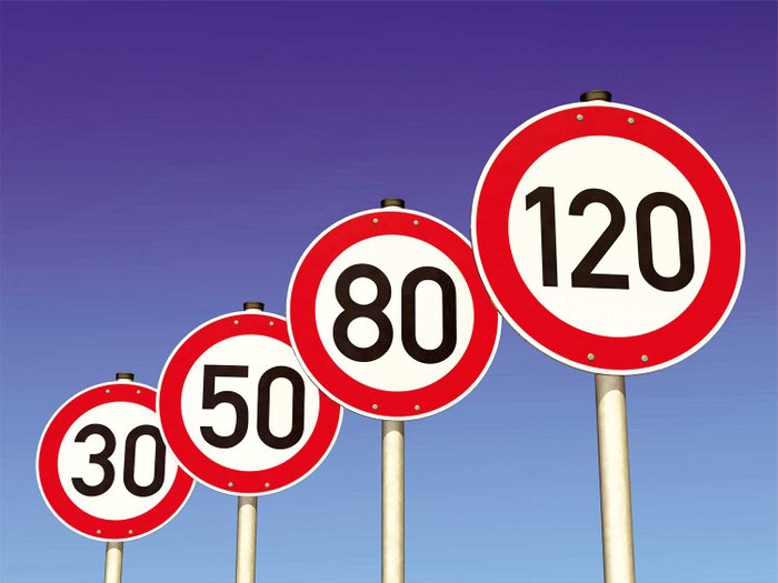 Verkehrszeichen-Schilder mit Geschwindigkeitsbeschränkungen stehen in einer Reihe.