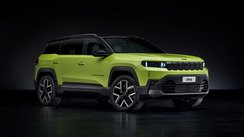 Grüner Jeep Compass vor dunklem Hintergrund.