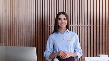Eine Frau an einer Hotel Rezeption.