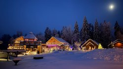 Das Lapland Guesthouse in Kangos im Schnee mit Weihnachtsbeleuchtung. 