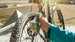 Frau putzt Fahrrad mit einem Schwamm. 