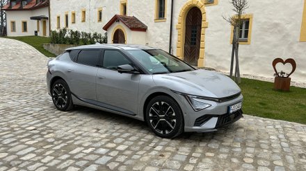 Kia EV6 steht vor einem Gebäude. 