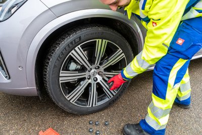 Der ARCD-Pannenhelfer dreht eine Radschraube fest.  