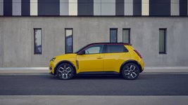 Renault 5 E-Tech parkt vor einem modernen Gebäude.