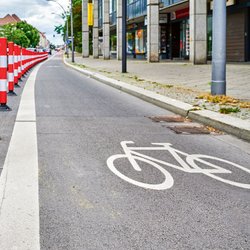 Radfahrstreifen in einer Stadt abgegrenzt durch Poller.