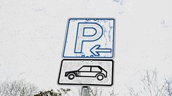 Ein Parkplatzschild mit einem Autosymbol darunter.