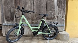 Grünes Fahrrad steht vor einer Holzwand