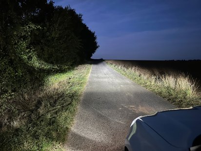 Halogener Scheinwerfer macht Licht auf einem Feldweg.