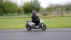 Eine Frau fährt den Elektroroller Honda CUV e