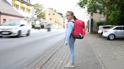 Schulkind möchte belebte Straße überqueren.