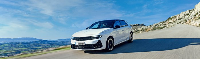 Ein weißer Opel Astra GSe fährt auf einer Bergstraße.