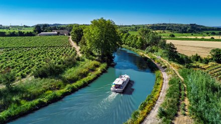 Hausboot fährt durch einen Kanal. 