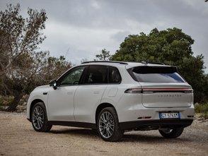 Leapmotor C10 REEV parkt vor Bäumen und Büschen. 