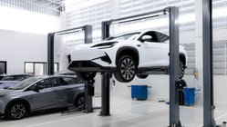  Ein E-Auto steht reparaturbereit auf einer Hebebühne in einer Werkstatt.