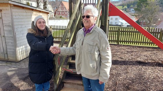 OC Mitglied und Erzieherin geben sich die Hand.