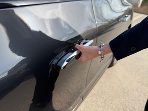 Frau öffnet den Türgriff des Mercedes-Benz EQE. 