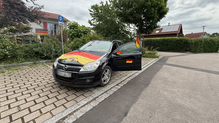 Ein Auto geschmückt mit Fanartikeln der Fußball-WM.