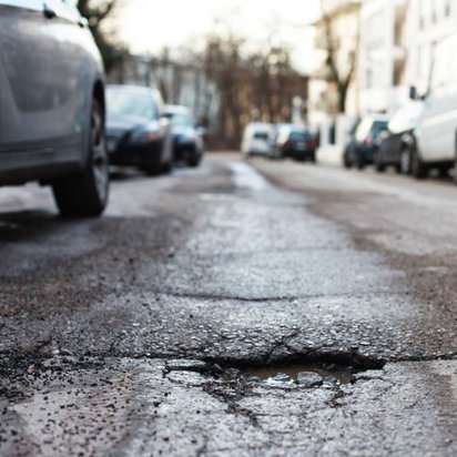 Nahaufnahme einer Straße mit Schlagloch.