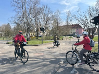 Senioren fahren mit dem Pedelec auf der Kreuzung des Übungsplatzes.