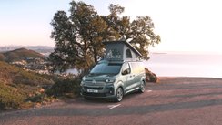 Ein Citroën Holidays Camper steht vor einer Landschaft am Meer.