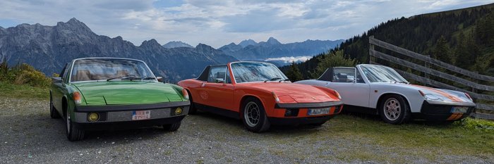 Drei Oldtimer stehen nebeneinander, im Hintergrund sind die Berge zu sehen.