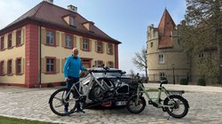 Wolfgang Sievernich steht mit Fahrrädern vor einem Auto. 