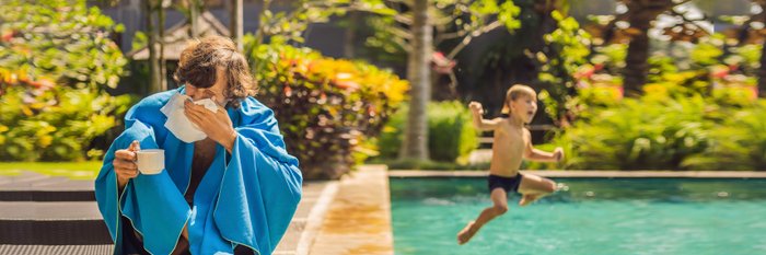 kranker Mann am Pool, im Hintergrund Kind das in den Pool springt.