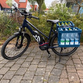Zwei Getränkekisten hängen am Adapter von Funcoo am Fahrrad.