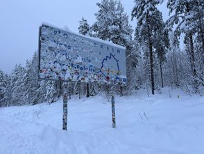 Das Schild am Polarkreis ist verschneit.