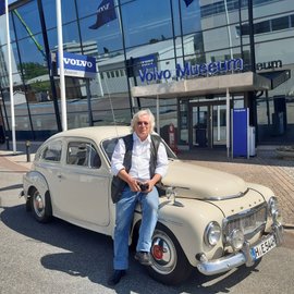 Mann mit Volvo Oldtimer vor Volvo-Museum.