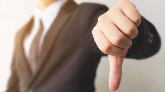 Mann zeigt Daumen runter. 